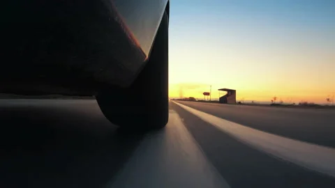 Low angle side view of car wheel driving, speeding fast at sunset 스톡 동영상 167664544