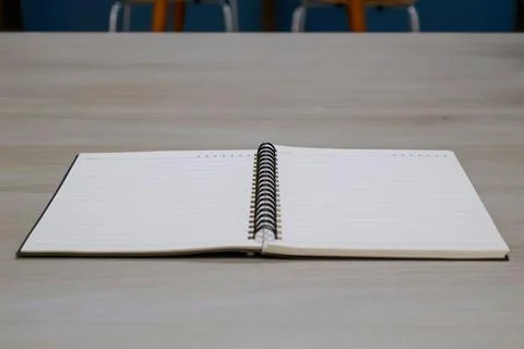 Low angle side view. Lined notebook page on wooden table background. Stock Photos