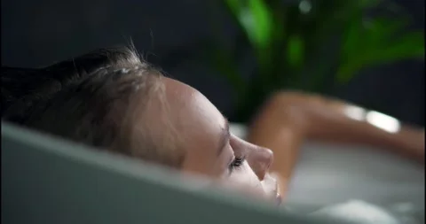 Low Angle Side View Shot of Young Beautiful Woman Lying in Bathtub with Closed Video stock 137959106