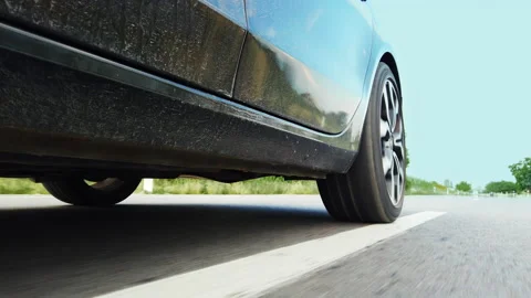 Low angle side view of sport car's tires speeding on the empty road Stock Footage 165373444