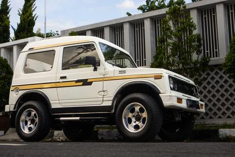 Low Angle Side View of White Classic Compact SUV with Yellow Stripes Parked.. Stock Photos