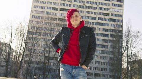 Low angle side of young male in a black leather jacket on street and looking  Foto stock