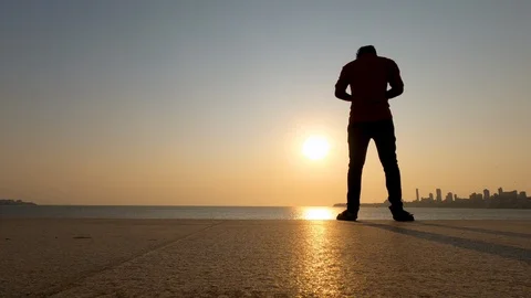 Low angle silhouette of man texting in front of city skyline Stock Footage 125155572
