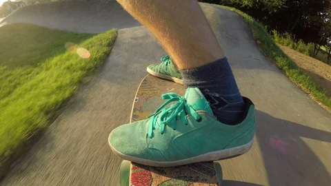 LOW ANGLE: Skateboarder riding trail flips his longboard and continues his run. Stock Footage 86720604