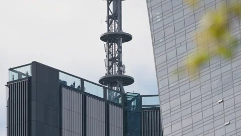 Low angle skyscraper rooftop observation deck with people behind glass Stock Footage 333651120
