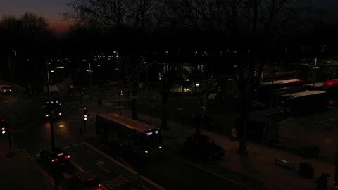 LOW ANGLE SLIDE AND PAN OF LONDON BUSY BUS STATION  AT SUNDOWN 스톡 동영상 150005505