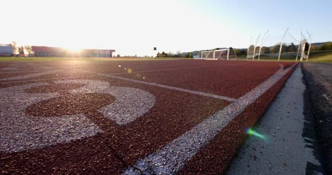 Low angle slider move on the running track at a highschool athletic field. Video stock 129105062