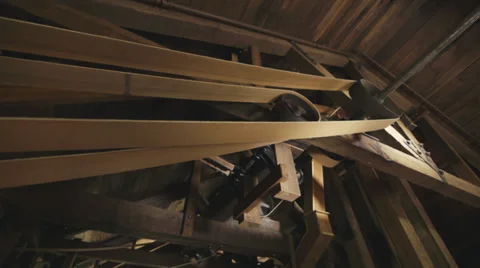 Low angle slider shot of belts and gears turning inside corn mill. Stock Footage 39218252
