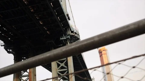 Low angle slider shot looking up at the Manhattan bridge in New York on a cloudy Stock Footage 98667894