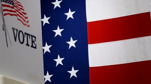 Low angle slider of voting booths against a large US Flag Stock Footage 125159791