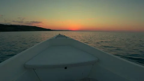 Low angle slow motion pov of yacht bow navigating toward sunset Видео 279899412