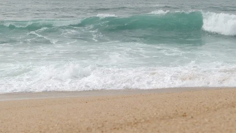 Low angle, slow motion shot of wave forming and breaking on beach Stock Footage 127126680