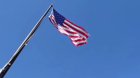 LOW ANGLE SLOW MOTION US FLAG OVER BLUE SKY Stock Footage 95825581