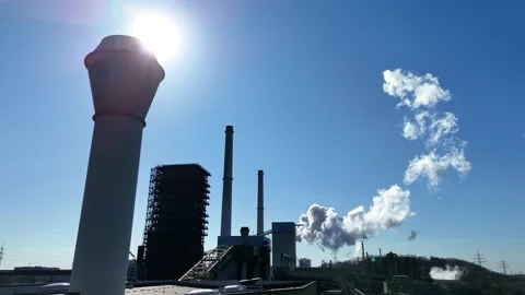 Low angle smokestack with sun cresting above Stock Footage 331205496
