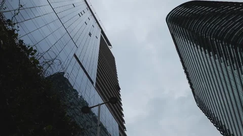 A low angle spinning shot of skyscrapers under overcast sky. Stock Footage 306710499