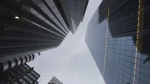 A low angle spinning view of glass skyscrapers in overcast day. Stock Footage 304843319