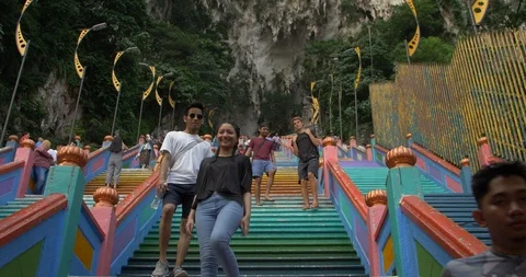 Low angle stabilzed walking up the colorful stairs at batu caves Stock Footage 112848116