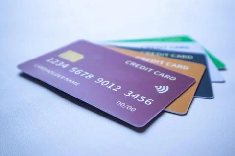 Low-angle stack of colorful credit cards featuring purple, orange, dark blu.. Stock Photos
