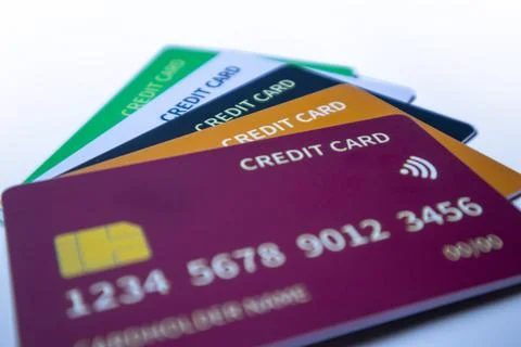Low-angle stack of colorful credit cards featuring purple, orange, dark blu.. Stock Photos