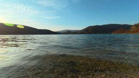 Low-Angle Static Lake Shot – Calm Water with Slow Pan, Autumn Evening Video stock 330988946