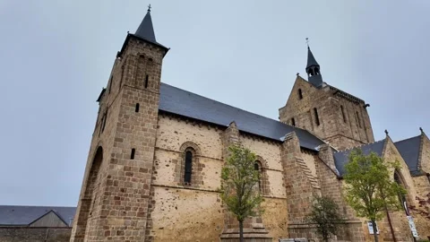 Low angle static shot of a medieval stone church facade with pointed towers unde Vídeos de archivo 332679586