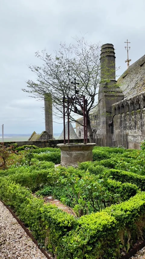 Low angle static shot of the Mont Saint-Michel Abbey towering over traditional s Vídeos de archivo 332724056