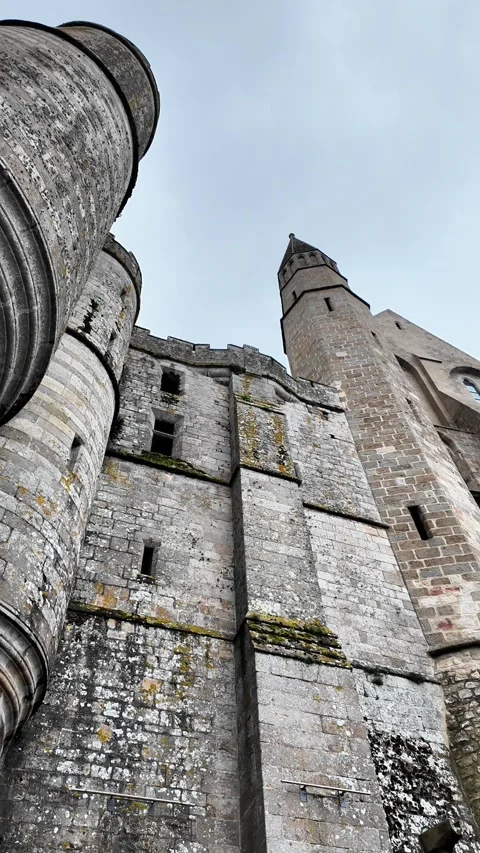 Low angle static shot of the Mont Saint-Michel Abbey towering over traditional s Vídeos de archivo 332724133