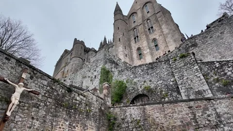 Low angle static shot of the Mont Saint-Michel Abbey towering over traditional s Vídeos de archivo 332724177