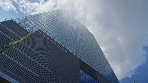 Low angle steady camera motion around modern office skyscraper glass facades Stock Footage 335728410