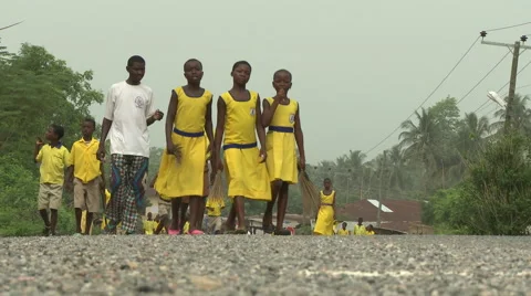 LOW ANGLE STUDENTS WALK DOWN THE ROAD CARRYING BROOMS AND MACHETES Stock Footage 60633379