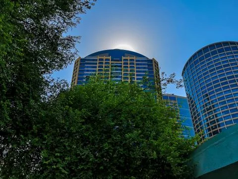 Low angle of a the sun behind a tower in Abu Dhabi city - Al Wahda Mall Stock Photos