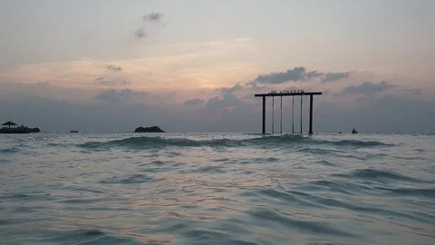 Low angle of swing in ocean in Maldives at dusk, panning Видео 279837311