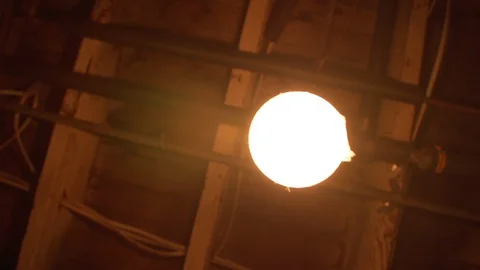 Low angle of swinging/flickering light bulb Stock Footage 109581888