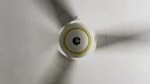Low angle symmetrical shot of a modern electric ceiling fan spinning fast o.. Stock-Footage 337583167