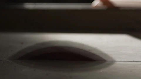 Low angle table saw blade teeth rising through the table Video stock 346256010