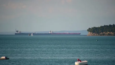 Low angle, telephoto view of two large tanker carrier ships anchored Stock Footage 161011339