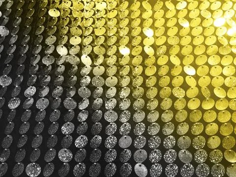 Low angle of textured background of round sequins in garlands shimmering 스톡 사진