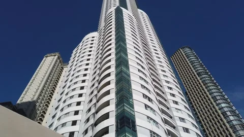 Low Angle Tilt Up of Modern Luxury Residential Skyscraper Against Clear Blue Sky Video stock 334725174