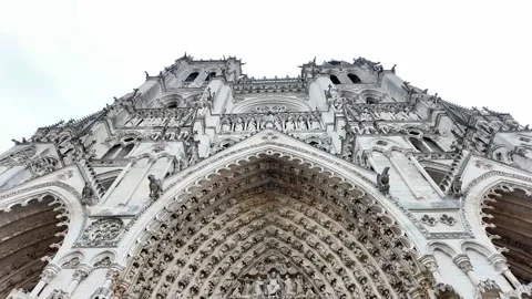 Low-angle tilt-up shot showcasing the highly detailed facade of a grand Gothic c Vídeos de archivo 332999816