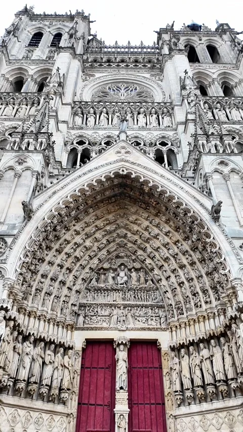 Low-angle tilt-up shot showcasing the highly detailed facade of a grand Gothic c Vídeos de archivo 332999817