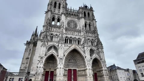 Low-angle tilt-up shot showcasing the highly detailed facade of a grand Gothic c Vídeos de archivo 332999833