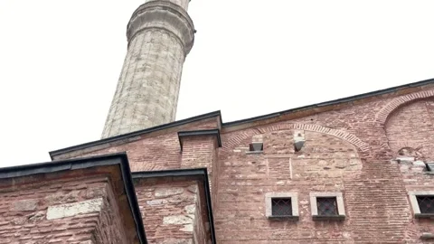 Low angle tilt up shot weathered red brick facade and stone minaret Stock Footage 340154957