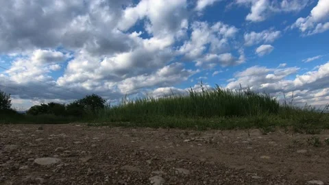 Low angle time lapse of clouds rolling over farming field Stock Footage 131298851