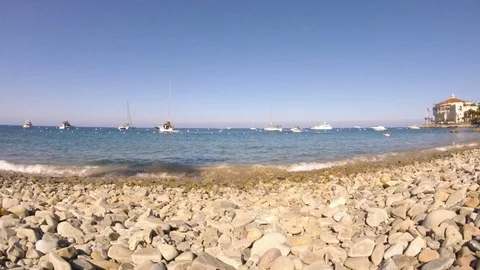 Low angle timelapse of rocky beach and boats on Catalina Island 動画素材 110929701
