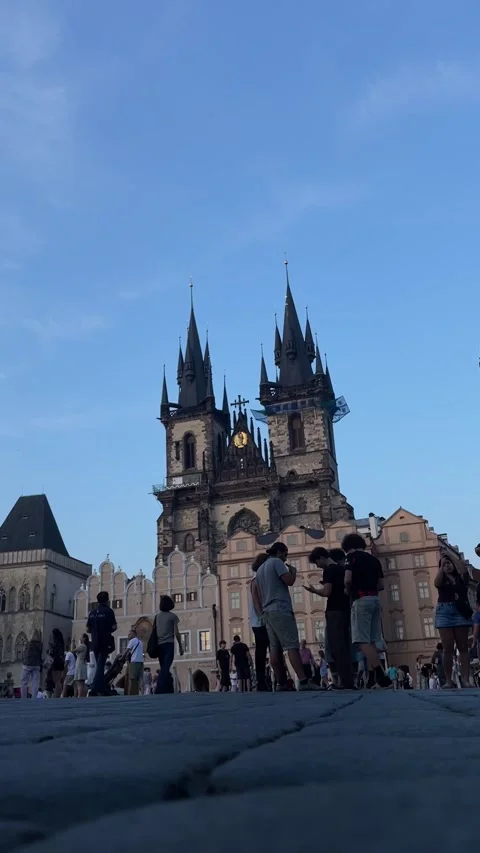 Low-angle tourists gathered in historic square before gothic cathedral with Vídeos de archivo 344585216