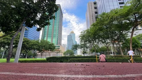 Low angle track oval with towering corporate skyscrapers in BGC 4K Stock Footage 337950684