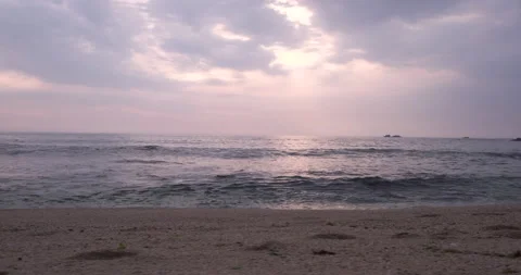 Low angle tracking shot along shoreline of beach at sunset Stock Footage 131756434