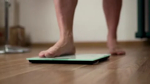 Low Angle Tracking Shot of Feet Walking to Weight Scale Vidéo 340219910