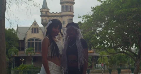 Low-angle tracking shot focusing on two girls enjoying a scenic park under a Vidéo 336650011