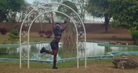 Low-angle tracking shot following a dark-skinned girl in a leather outfit and Vidéo 336766088
